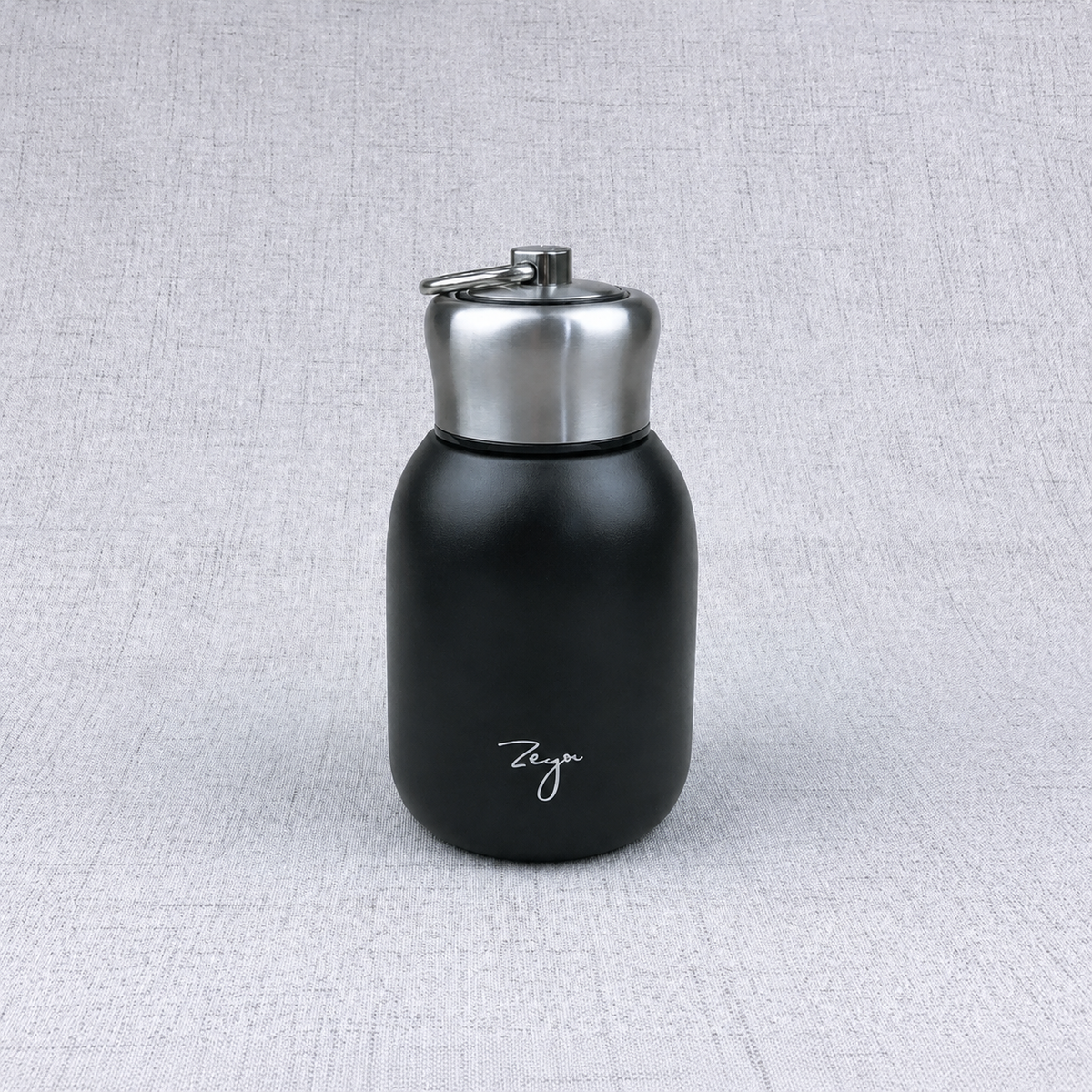 Compact insulated bottle in black, with stainless-steel lid and metal carrying loop.