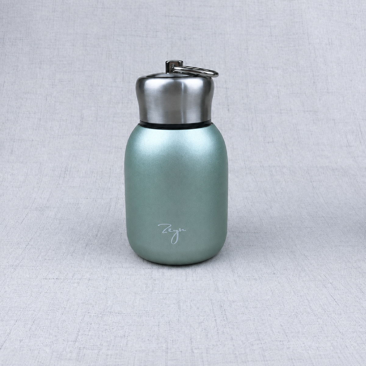 Compact insulated bottle in green, with stainless-steel lid and metal carrying loop.