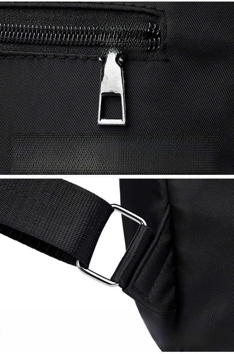 Close-up of a black sling bag showing a silver metal zipper pull and a black adjustable strap with a silver metal buckle, on a white background.