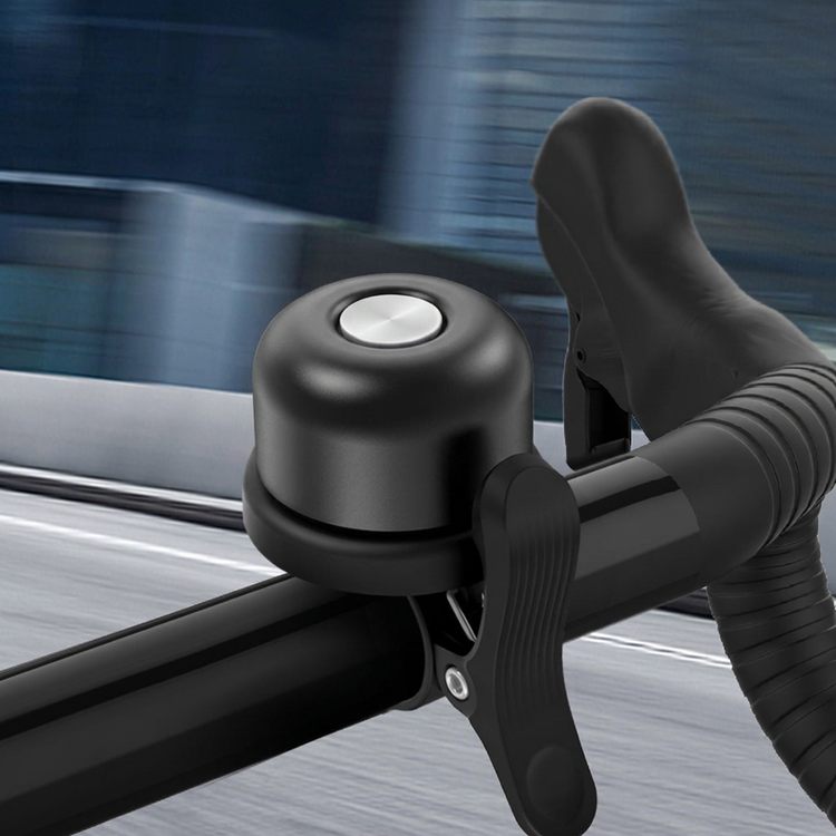 Black bicycle bell on handlebars with all wording removed
